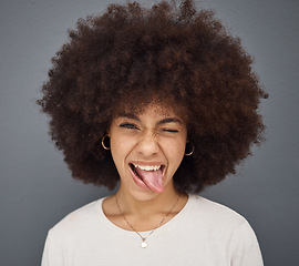 Image showing Goofy, face and woman with her tongue out in studio with comic, fun and crazy facial expression. Silly, funny and portrait of happy girl model from Puerto Rico standing and posing by gray background.