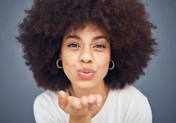 Image showing Face, portrait and woman blowing a kiss on a grey studio background being flirty and seductive. Fun, flirting and beautiful african american female kissing and being alluring and isolated on backdrop