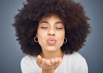 Image showing Kissing, love and romance with a black woman blowing a kiss in studio on a gray background for romantic affection. Beauty, lips and flirt with an attractive young female making a mouth gesture
