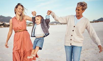 Image showing Happy, mother and grandmother holding hands with child at the beach for fun family time together in the outdoors. Mama, grandma and kid swinging in the air for playful walk at the sandy ocean outside