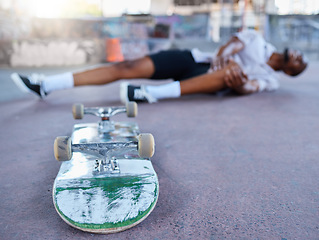 Image showing Skateboard, skater and knee injury in street, city or outdoors after failed stunt or accident. Skateboarding, sports and black man with sore leg, joint inflammation or muscle pain at urban skate park