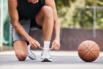 Image showing Basketball, shoes and hands by man on the ground for lace before exercise, training and cardio at a basketball court. Fitness, sneakers and basketball player getting ready for workout, sport and game