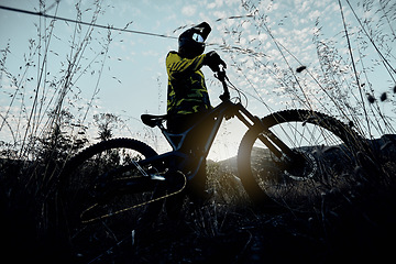 Image showing Nature cycling, blue sky and man with mountain bike for cardio workout, fitness journey or travel in countryside below view. Dark shadow flare, exercise and athlete rider training for triathlon race