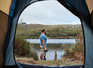 Image showing Man by lake from tent view, outdoor and camping for adventure, vacation or holiday in nature. Explorer, binocular and morning for sightseeing by river, dam or water on natural rest, relax or retreat