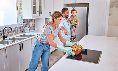 Image showing Family, cooking and home kitchen with a mother, father and child waiting for dinner, food and a healthy meal. Man, woman and baby in house for bonding, eating and nutrition with roasted chicken