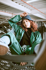 Image showing Fashion, gen z and woman in a shopping cart with stylish clothes and cool look in city street style. Portrait of a model girl and teenager from Spain in a garage parking lot with an urban outfit