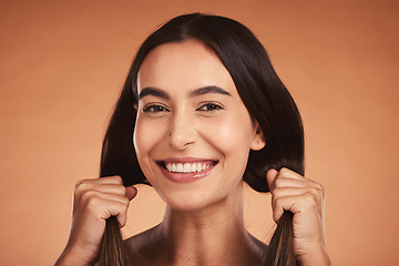 Image showing Portrait of woman holding hair for beauty, hairstyle and fashion isolated on orange background in studio. Beauty salon, smile and face of young female with healthy skin, wellness and hair products