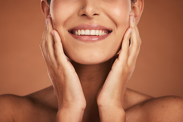 Image showing Woman, hands and smile with teeth in skincare beauty or facial treatment against a studio background. Hand of female model touching face and smiling in luxury satisfaction for perfect skin cosmetics
