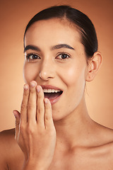 Image showing Wow, gossip, and woman with hand for beauty, makeup and cosmetics against a brown studio background. Skincare, happy and young model with surprise from cosmetic care, cosmetology and dermatology