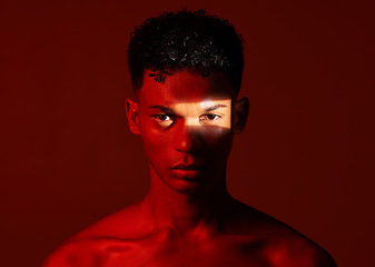 Image showing Beauty, red studio and portrait of a man with with a ray of light on his face with a skincare routine. Health, spotlight and model with a wellness skin treatment isolated by a brown background.