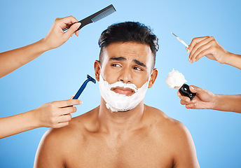 Image showing Face, shave and grooming with hands holding equipment for shaving or brushing hair in studio on a blue background. Skincare, wellness and luxury with an unhappy male customer at the barber for beauty