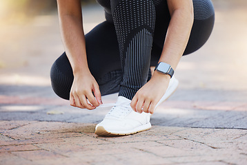 Image showing Woman, hands and shoelaces tie for fitness, workout or training on city road, street or urban location. Zoom, runner or sports athlete running shoes on concrete ground for marathon or cardio exercise