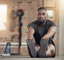 Image showing Black man, stretching and fitness in gym workout, training and exercise with health goals, motivation or wellness target. Bodybuilder, sports athlete or personal trainer in warmup for muscle relief