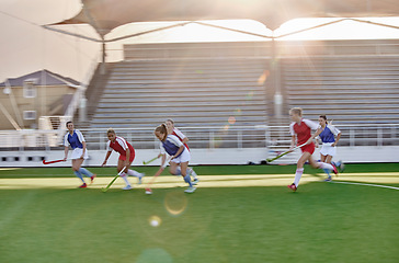 Image showing Women, hockey and sports on grass field, turf and pitch for competition, games and team training in outdoor sunshine. Girls field hockey players contest, action and performance match in stadium arena