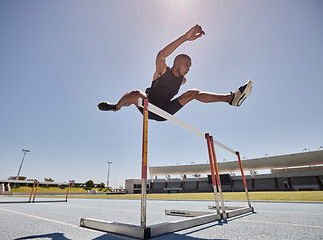 Image showing Running, jump and athlete hurdle for a speed exercise, marathon or runner training in a stadium. Short health, cardio and man run fast for a jumping competition or fitness workout for sports wellness