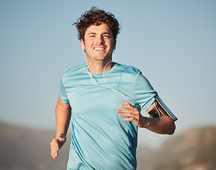 Image showing Happy, running and man athlete with music steaming in nature for fitness and training in nature. Portrait of a happy, healthy and smile of a runner in the sun doing a cardio sports workout exercise