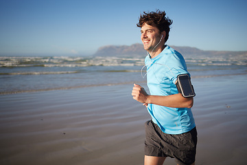 Image showing Music, fitness and man running on beach, happy and relax with radio, audio and morning cardio. Podcast, exercise and guy runner training along the ocean, smile and enjoy summer, wellness and workout