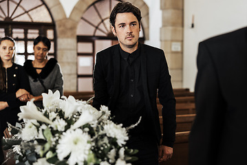 Image showing Funeral, death and grief with a man pallbearer carrying a coffin in a church during a ceremony. Flowers, suit and loss with a male holding a casket while walking through a chapel for mourning