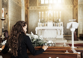 Image showing Funeral coffin, death and woman in church after the loss of family, friend or loved one from cancer. RIp, mourning and back view of female with flowers on wood casket in cathedral for burial ceremony