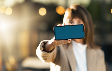 Image showing Hands, business woman and phone with green screen for advertising, marketing or promotion. Mockup space, professional lady and closeup of smartphone, cellphone or mobile device with chroma key screen