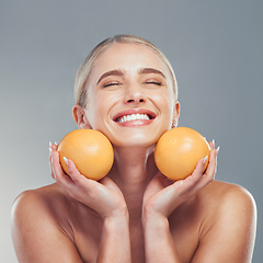 Image showing Orange, skincare and woman in studio with fruit for a natural beauty facial cosmetics product with mockup space. Smile, vitamin c and happy young girl detoxing her glowing face organically to relax