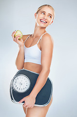 Image showing Apple, diet and woman with scale for body health, self care and natural weight loss. Eating healthy food, nutrition lifestyle and wellness exercise training for fat workout in gray studio background