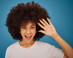 Image showing Brazilian woman, afro or surprise face on blue background in studio in waving, hi or greeting hand gesture. Portrait, smile or happy model and excited or comic facial expression and fashion hairstyle
