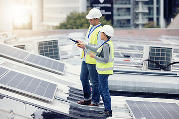 Image showing Sustainable engineering, solar panels and team doing maintenance on the rooftop of building in the city. Solar energy, ecology and industrial workers planning project with photovoltaic cells in town.