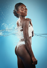 Image showing Black woman, water splash and hygiene shower, cleaning and skincare for clean body, hygiene and wellness. Relax, luxury and wellness with an attractive young female posing in bathroom or beauty wash