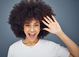 Image showing Hand, wave and excitement with an afro black woman in studio on a gray background greeting with a smile. Portrait, hair and happy with an attractive young female waving to welcome or say hello