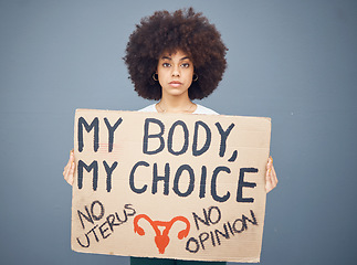Image showing Black woman afro, protest and poster for abortion, female choice or decision against a studio background. Portrait of African American female taking a stand holding cardboard sign for empowerment