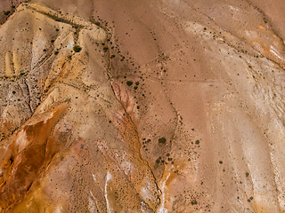 Image showing Aerial shot of the textured yellow nad red mountains resembling the surface of Mars