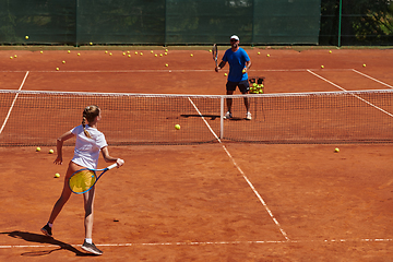 Image showing A professional tennis player and her coach training on a sunny day at the tennis court. Training and preparation of a professional tennis player