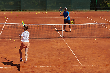 Image showing A professional tennis player and her coach training on a sunny day at the tennis court. Training and preparation of a professional tennis player