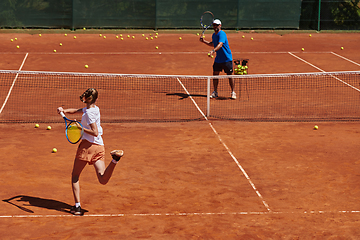 Image showing A professional tennis player and her coach training on a sunny day at the tennis court. Training and preparation of a professional tennis player