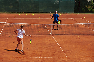 Image showing A professional tennis player and her coach training on a sunny day at the tennis court. Training and preparation of a professional tennis player