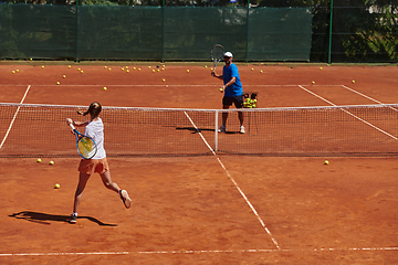 Image showing A professional tennis player and her coach training on a sunny day at the tennis court. Training and preparation of a professional tennis player