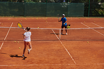 Image showing A professional tennis player and her coach training on a sunny day at the tennis court. Training and preparation of a professional tennis player