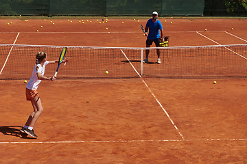 Image showing A professional tennis player and her coach training on a sunny day at the tennis court. Training and preparation of a professional tennis player