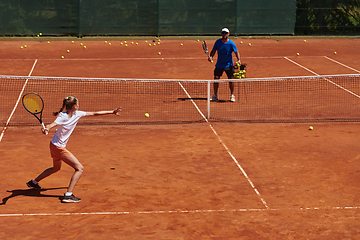 Image showing A professional tennis player and her coach training on a sunny day at the tennis court. Training and preparation of a professional tennis player