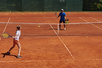 Image showing A professional tennis player and her coach training on a sunny day at the tennis court. Training and preparation of a professional tennis player