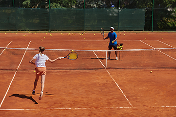 Image showing A professional tennis player and her coach training on a sunny day at the tennis court. Training and preparation of a professional tennis player