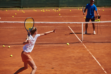 Image showing A professional tennis player and her coach training on a sunny day at the tennis court. Training and preparation of a professional tennis player