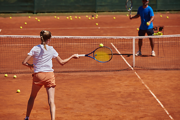 Image showing A professional tennis player and her coach training on a sunny day at the tennis court. Training and preparation of a professional tennis player