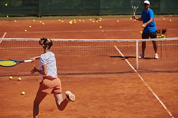 Image showing A professional tennis player and her coach training on a sunny day at the tennis court. Training and preparation of a professional tennis player