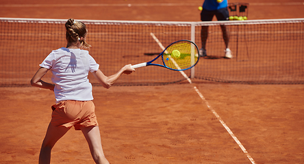 Image showing A professional tennis player and her coach training on a sunny day at the tennis court. Training and preparation of a professional tennis player