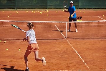 Image showing A professional tennis player and her coach training on a sunny day at the tennis court. Training and preparation of a professional tennis player