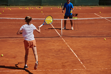 Image showing A professional tennis player and her coach training on a sunny day at the tennis court. Training and preparation of a professional tennis player