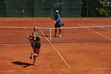 Image showing A professional tennis player and her coach training on a sunny day at the tennis court. Training and preparation of a professional tennis player