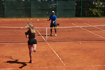 Image showing A professional tennis player and her coach training on a sunny day at the tennis court. Training and preparation of a professional tennis player